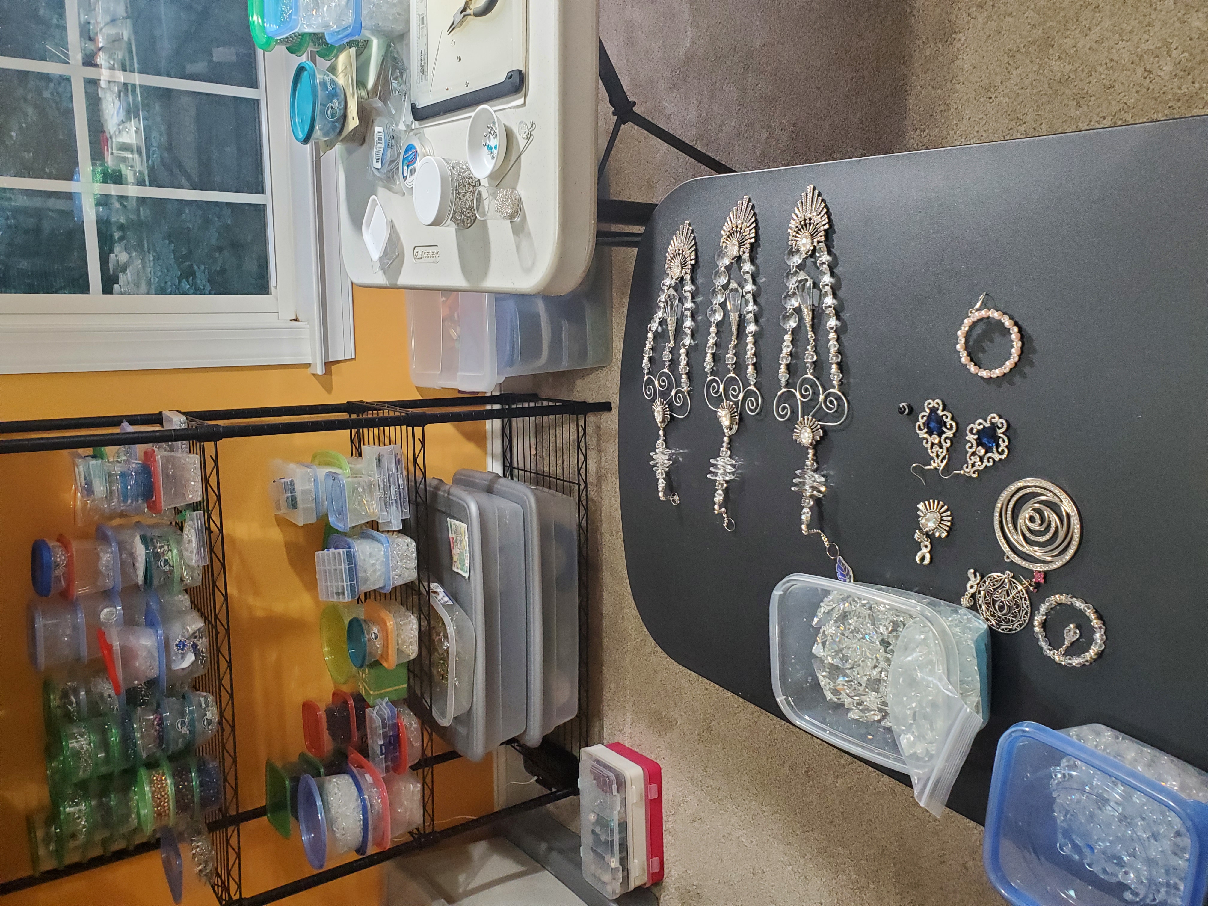 Petra's workspace showing beads, wire, and tools organized for creating handcrafted suncatchers and spiders